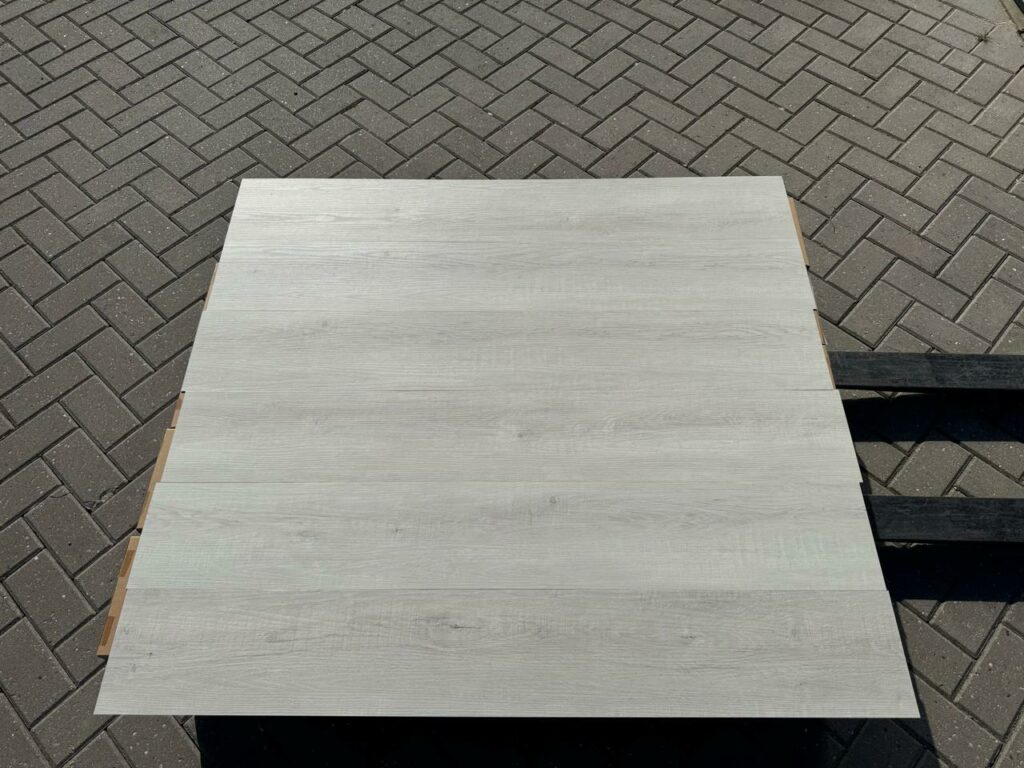 Bovenaanzicht van de planken van de Floordeals 3012 plak pvc vloer in grijs eiken, vlak naast elkaar gelegd